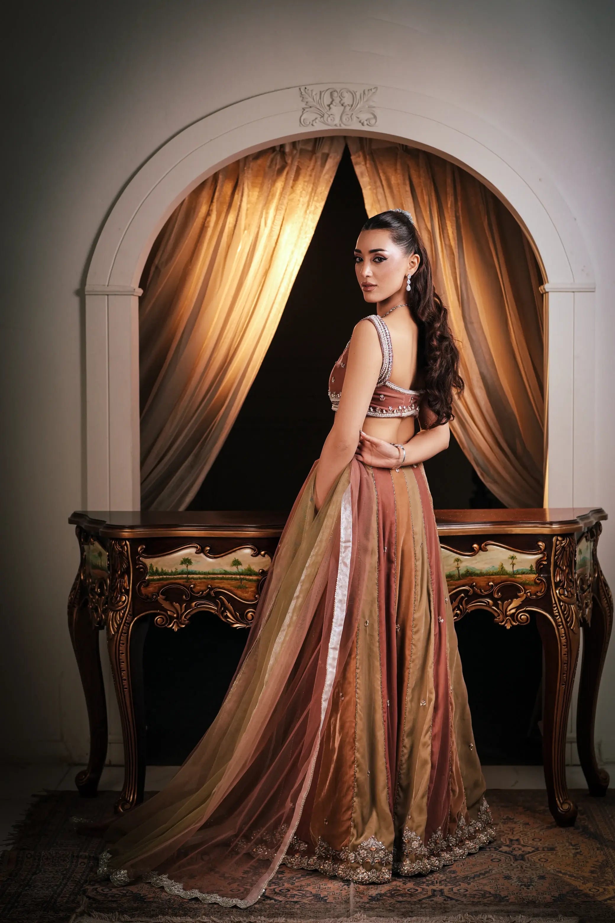 Full-length side view of a multi-panel bridal lehenga in copper, olive green and antique gold, showing the flared