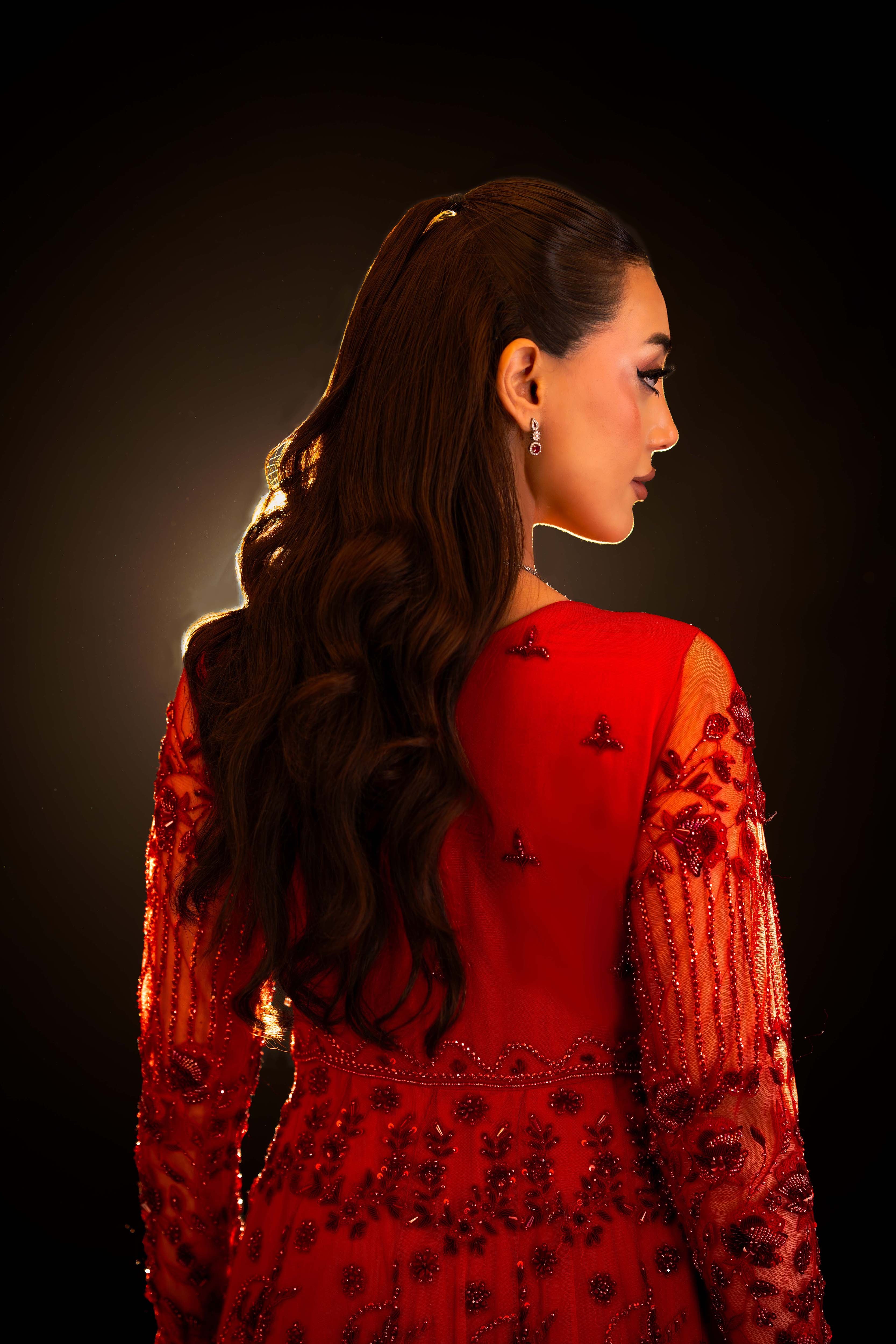 Back view of red bridal gown with floral embroidery, beaded sleeves on sheer fabric