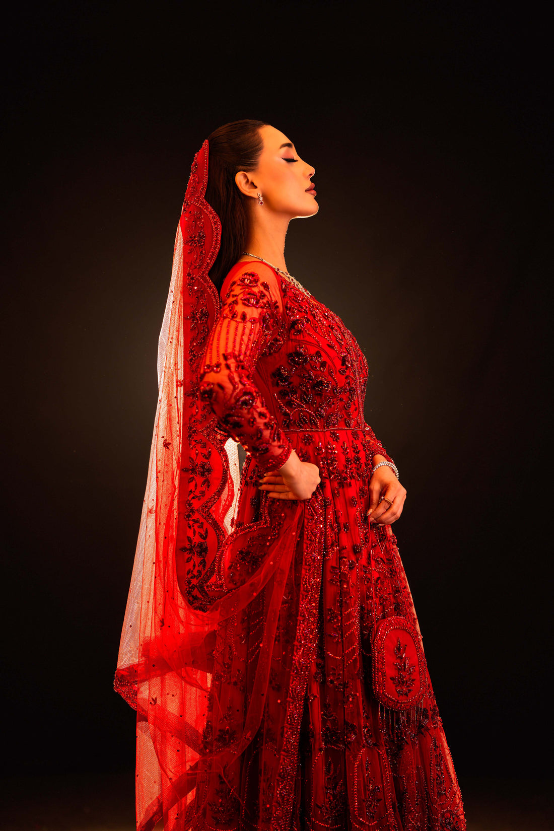 Profile view of red bridal outfit with sequin and bead embroidery, sheer fabric flowing