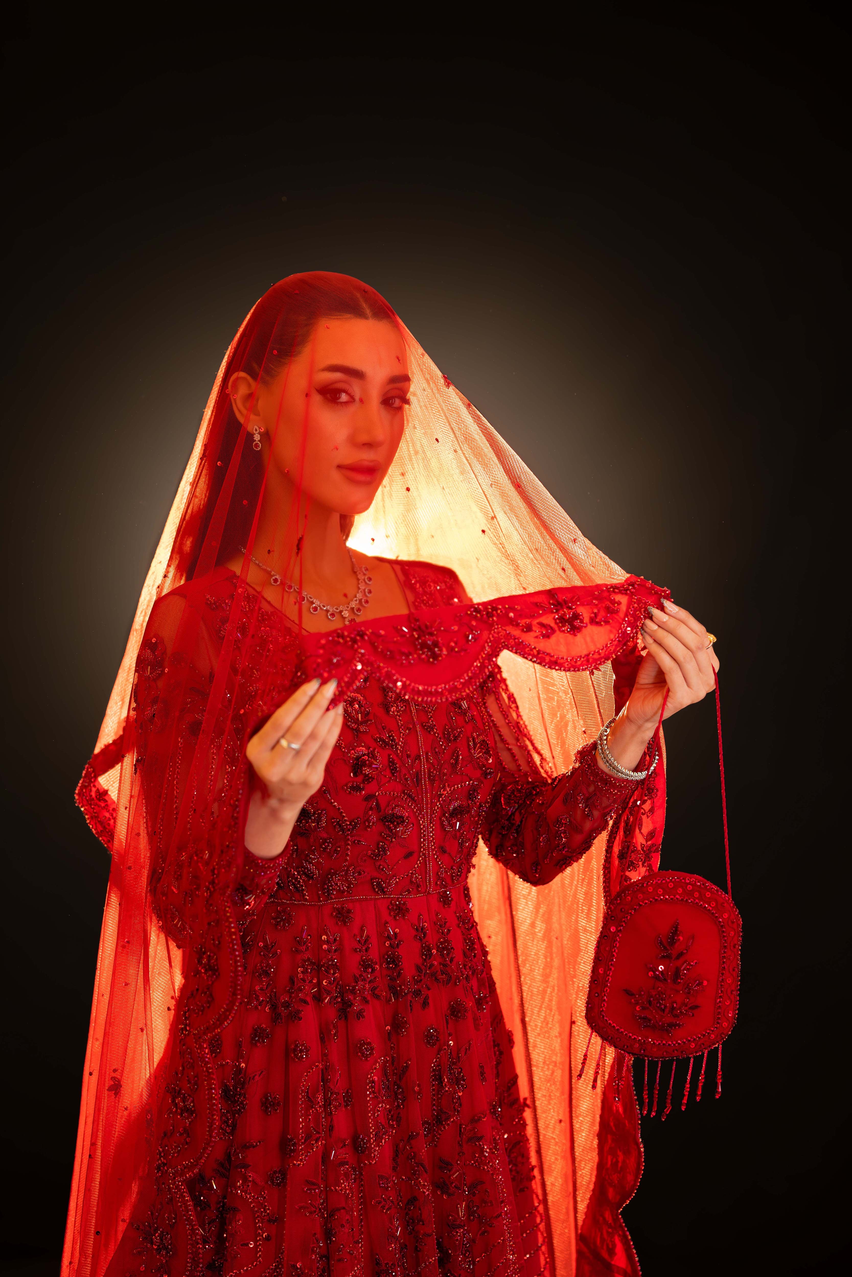 Close-up of red bridal ensemble with sequin embroidery and sheer dupatta