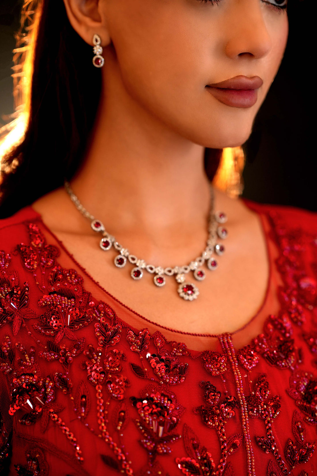 Close-up of red bridal blouse with floral embroidery and beadwork on sheer fabric