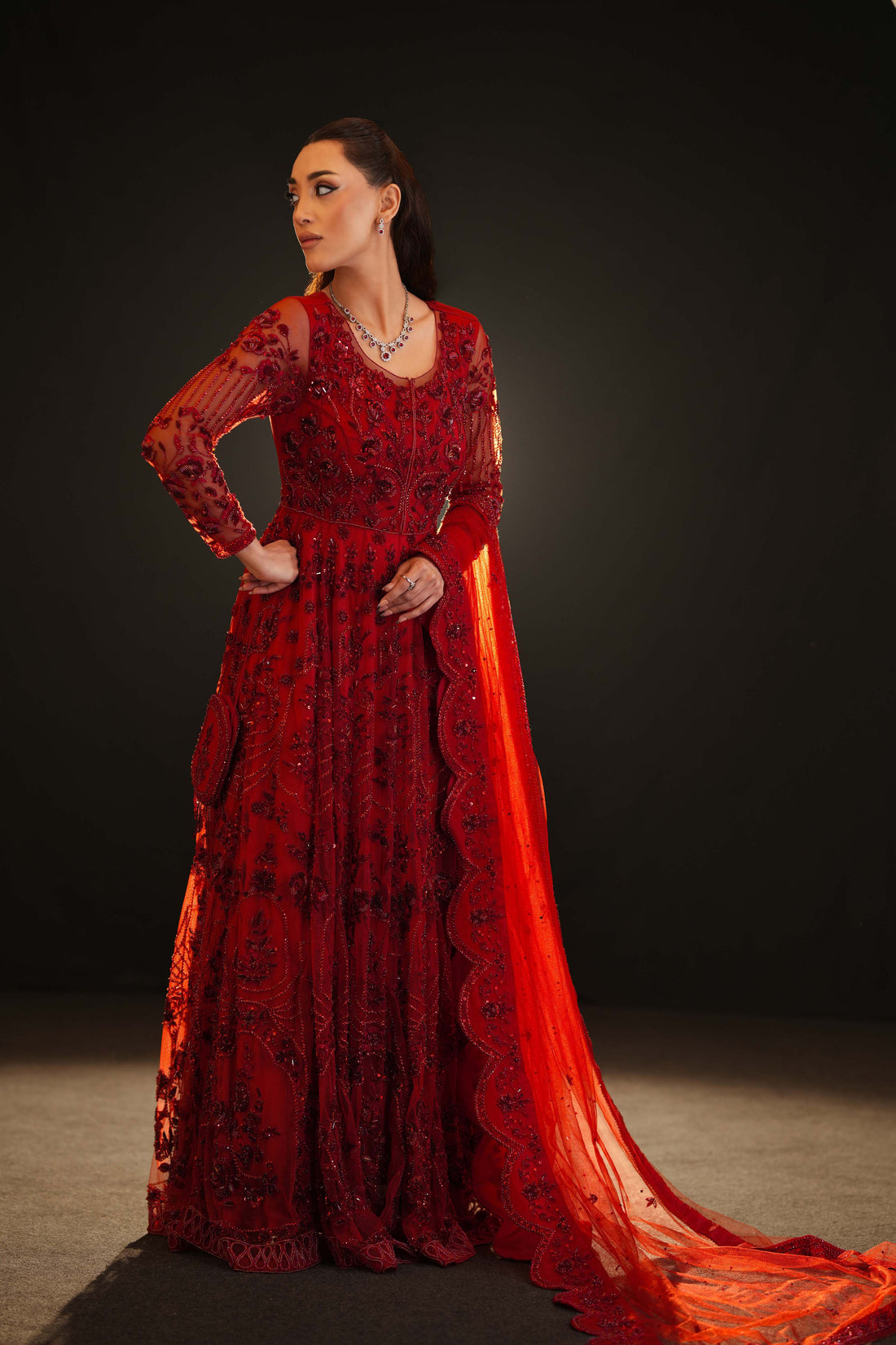 Side view of red bridal outfit with floral embroidery and scalloped dupatta trailing