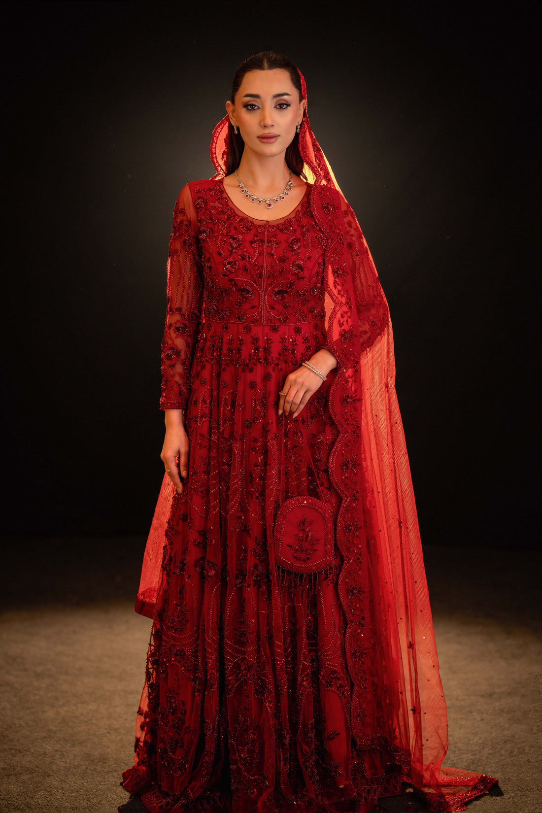Front view of red bridal gown with detailed sequin embroidery and ornate dupatta border