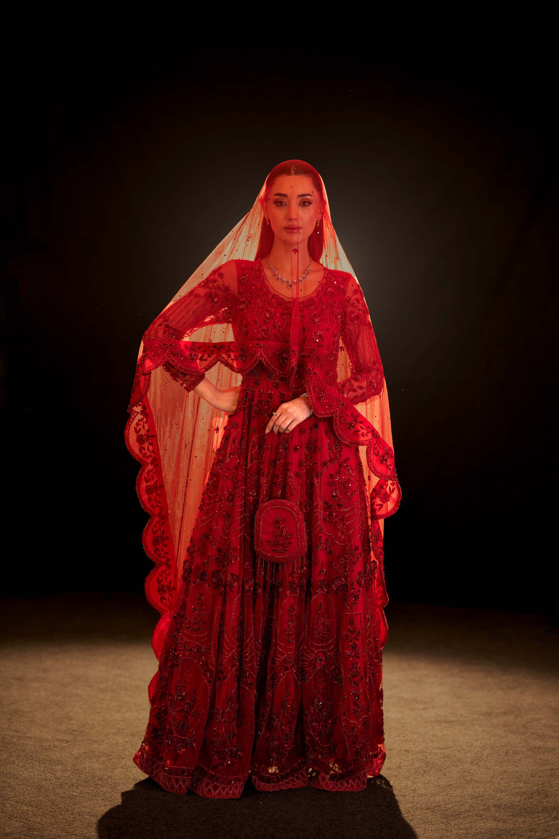 Front view of red bridal gown with intricate embroidery and sequins on sheer fabric