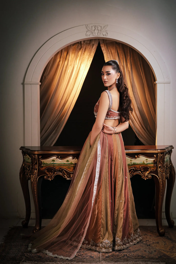Full-length side view of a multi-panel bridal lehenga in copper, olive green and antique gold, showing the flared